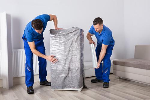 Helden Umzüge - Verpacken von Umzugsgut Helden Umzüge - Verpacken von Umzugsgut - Männer verpacken Umzugsgut in Folie